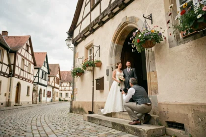 Photographe de mariage capturant un couple de mariés devant une église alsacienne traditionnelle dans le Bas-Rhin